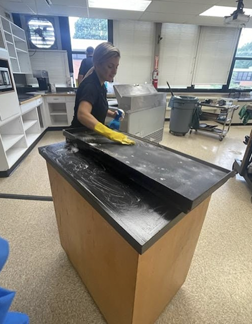 Custodial staff cleaning classroom