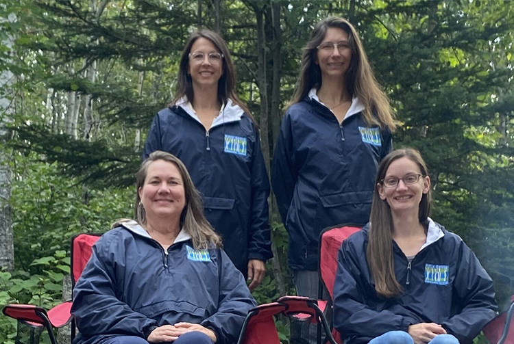 Community Service staff members sitting around a camp fire