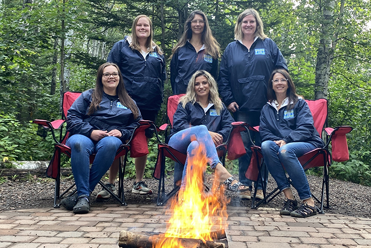 Elementary staff members sitting around a camp fire